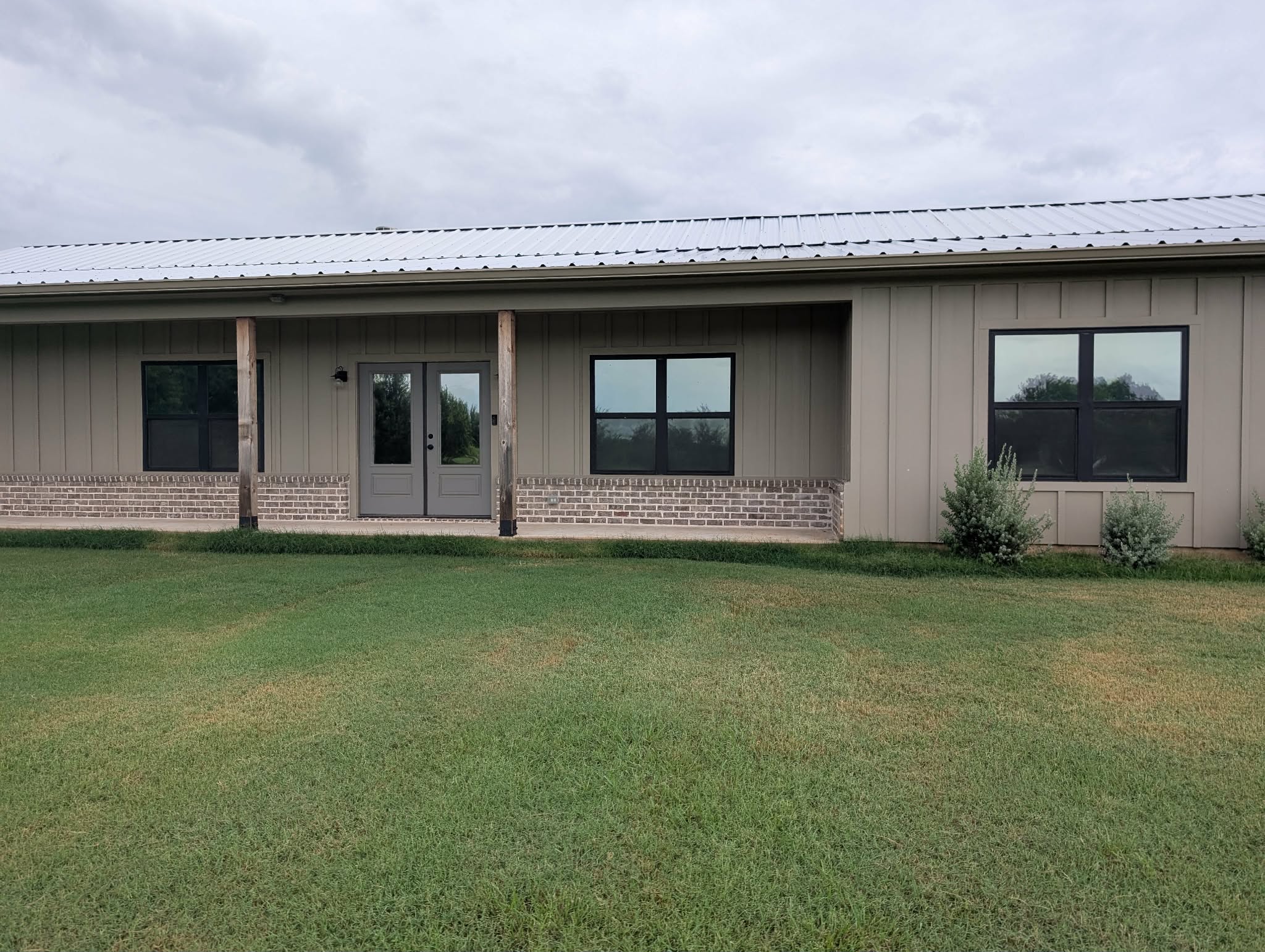 Metal-sided home exterior with tinted windows and French doors